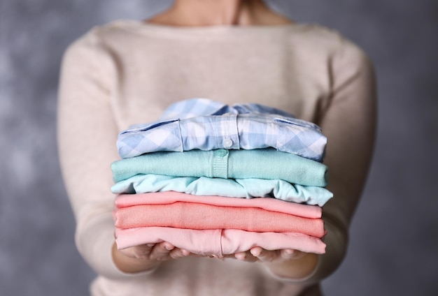 Mujer con ropa lavada y seca en un fondo gris