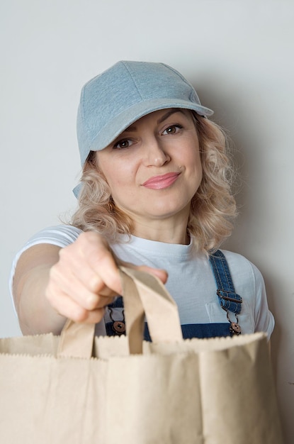 Mujer en ropa de mensajería tiene bolsa ecológica