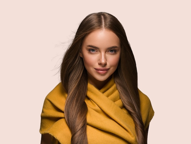 Mujer en ropa de punto amarillo otoño invierno estilo pelo largo. Fondo de color amarillo