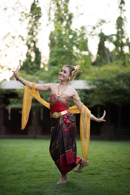 Foto mujer con ropa tradicional posando contra los árboles