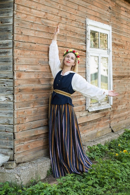 Foto mujer en ropa tradicional posando sobre la naturaleza en el pueblo