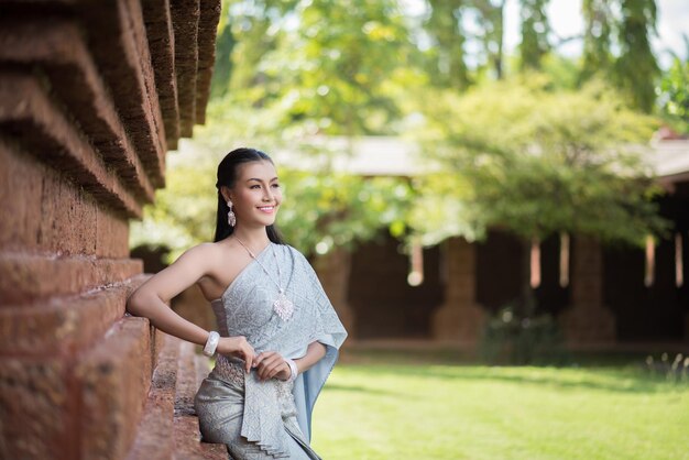 Foto mujer con ropa tradicional sentada junto a la pared