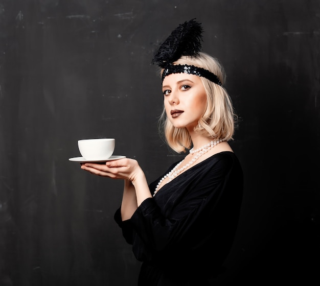 Foto mujer en ropa de veinte años con taza de café