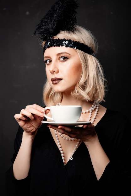 Foto mujer en ropa de veinte años con taza de café