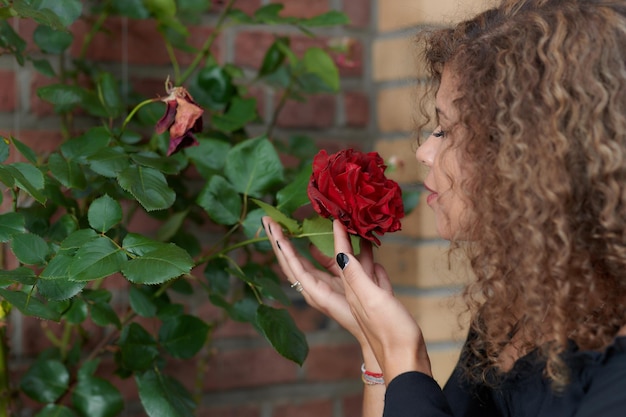 Foto mujer con una rosa roja en la planta