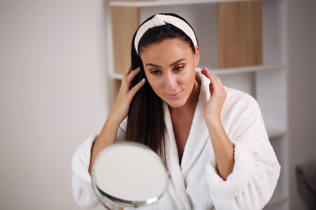 Mujer con rostro de belleza tocando retrato de piel sana