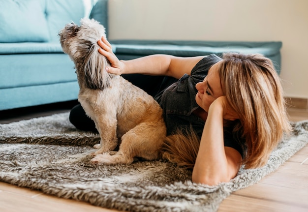 Foto mujer rubia acariciando lindo perrito