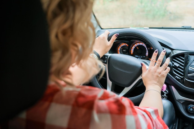 Mujer rubia adulta conduciendo un coche vista interior