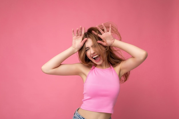 Mujer rubia atractiva joven loca con emociones sinceras aisladas en la pared de fondo con copia