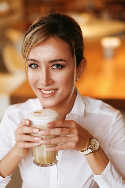 Mujer rubia bebiendo café por la mañana en el restaurante