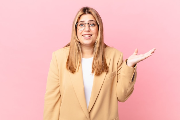 Mujer rubia bonita con curvas que se siente feliz, sorprendida al darse cuenta de una solución o idea