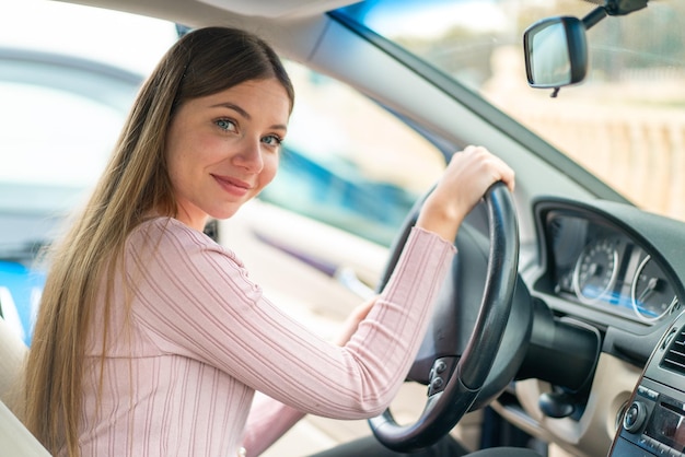 Mujer rubia bonita joven dentro de un coche