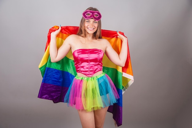 Mujer rubia brasileña vestida con ropa de carnaval rosa con bandera lgbt orgullo lgbt