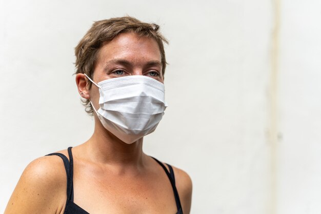 Mujer rubia con cabello corto y una máscara en la cara para protegerla de virus