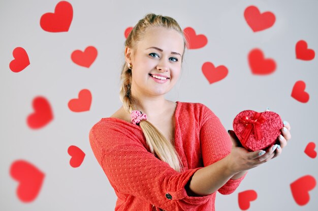 Mujer rubia con una caja de forma de corazón