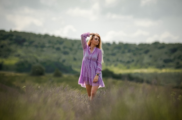 Mujer rubia caminando por el campo de lavanda