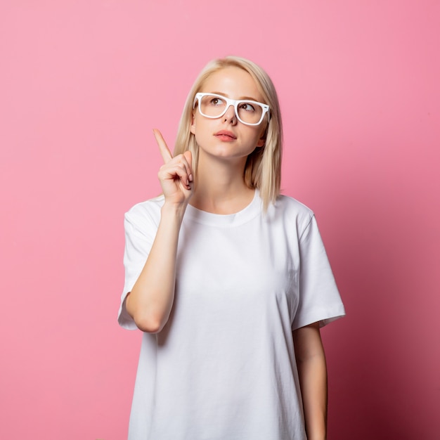 Mujer rubia en camiseta blanca y gafas