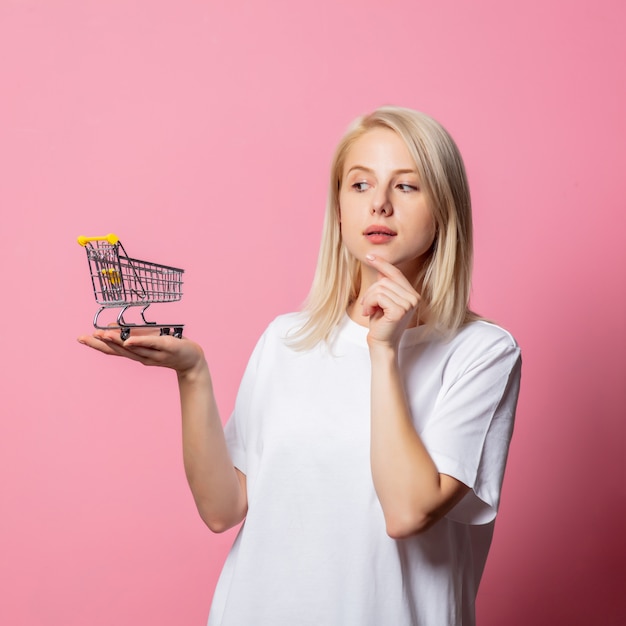 Mujer rubia en camiseta blanca en rosa