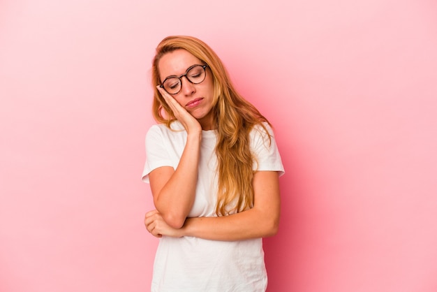 Mujer rubia caucásica aislada sobre fondo rosa que está aburrida, fatigada y necesita un día de relax.