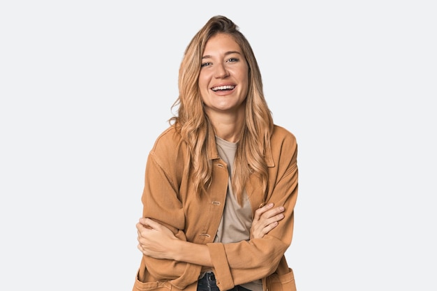 Mujer rubia caucásica en el estudio riendo y divirtiéndose