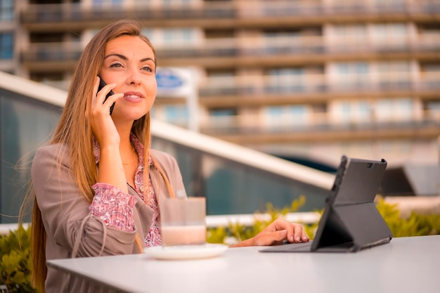 Mujer rubia comercial desayunando un café descafeinado en una llamada de negocios con un cliente