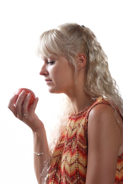 Mujer rubia comiendo una manzana