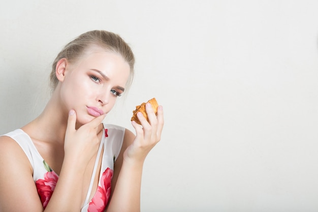 Mujer rubia de dieta descontenta con delicioso postre con crema. Espacio para texto