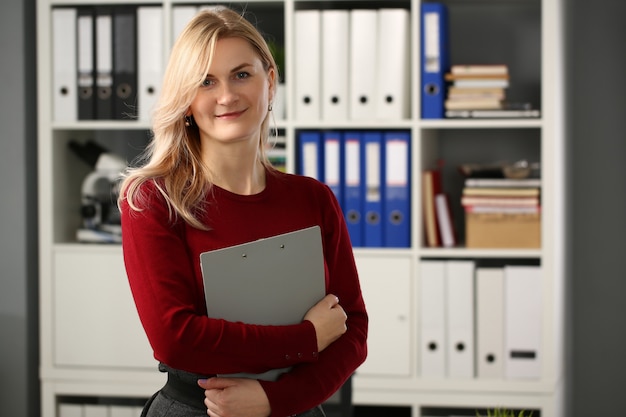 Mujer rubia encantada positiva que mira la cámara