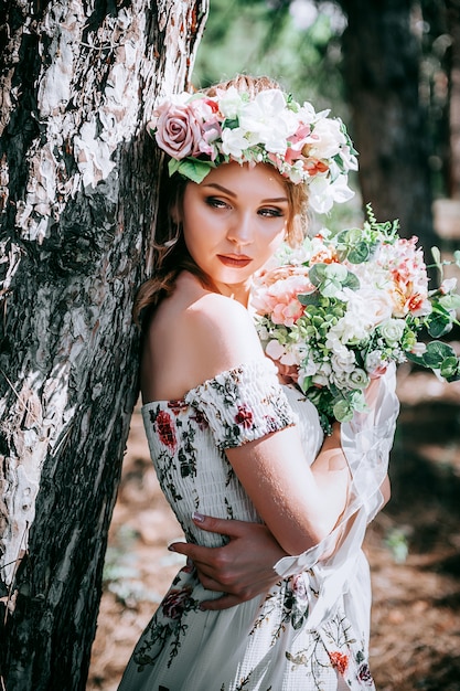 mujer rubia con estilo floral en un bosque verde