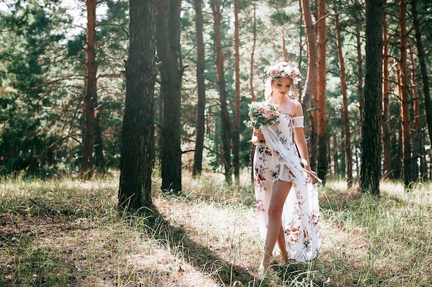 mujer rubia con estilo floral en un bosque verde