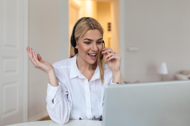 Mujer rubia feliz con auriculares y micrófono mirando la cámara web sonriendo a la cámara riéndose durante una reunión virtual o una videollamada Empleado trabajando desde casa Vista de la pantalla Captura de cabeza