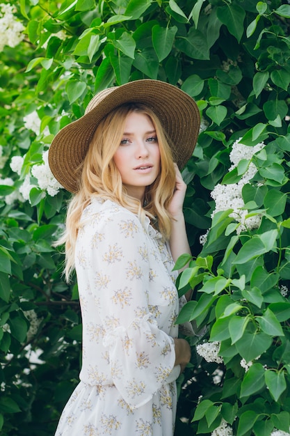 Mujer rubia con flores lilas en la primavera