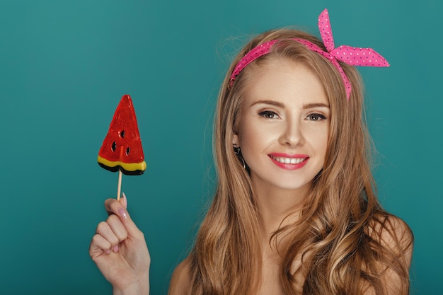 Mujer rubia con fondo azul piruleta.