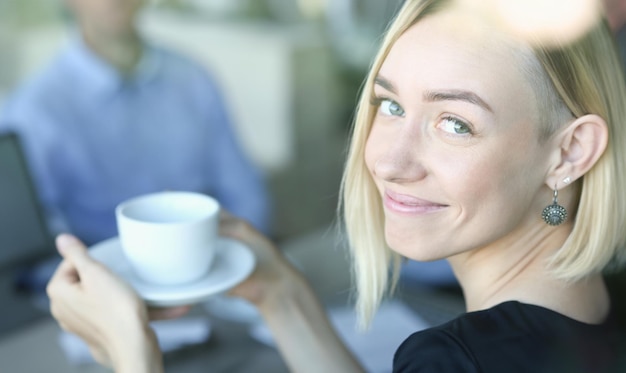 Mujer rubia hablando con amigos en un café