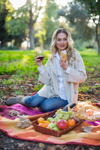 Mujer rubia haciendo un picnic en el parque