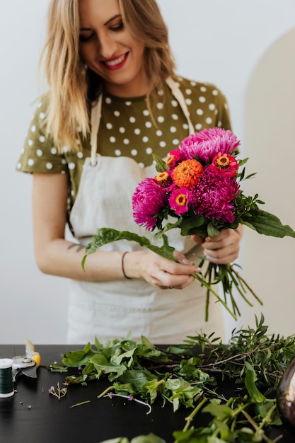 Mujer rubia haciendo un ramo de flores