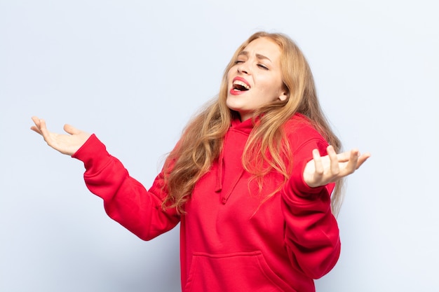 Mujer rubia interpretando ópera o cantando en un concierto o espectáculo, sintiéndose romántica, artística y apasionada