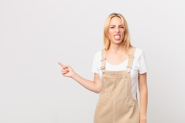 Mujer rubia joven con actitud alegre y rebelde, bromeando y sacando la lengua