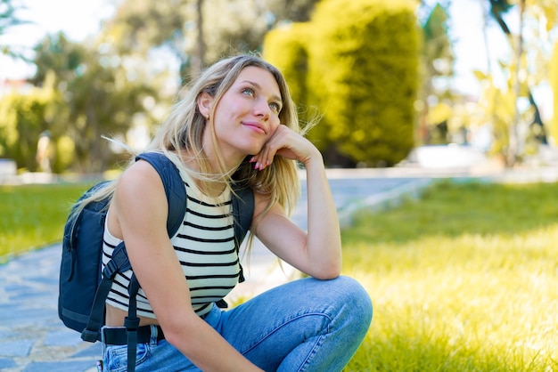 Mujer rubia joven al aire libre con expresión feliz