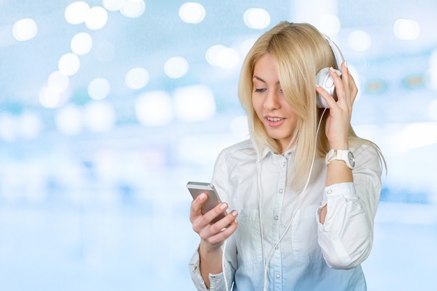 Mujer rubia joven feliz que escucha la música