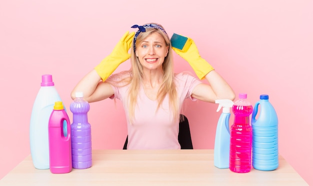 Mujer rubia joven que se siente estresada, ansiosa o asustada, con las manos en la cabeza. concepto de ama de llaves