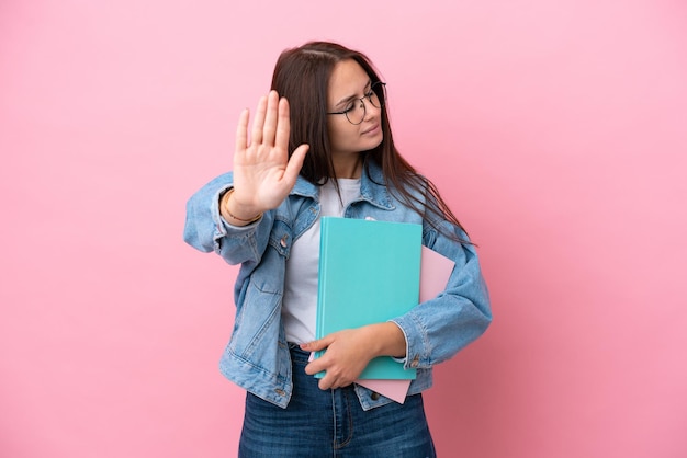 Mujer rubia joven sobre fondo aislado con una cámara profesional