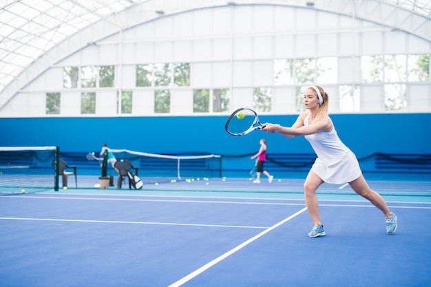 Mujer rubia jugando tenis