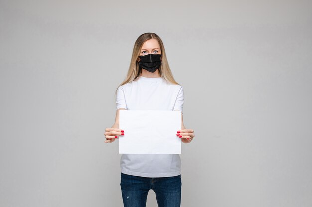 Mujer rubia en máscara con banner en blanco.