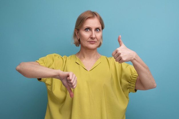 Mujer rubia de mediana edad segura de sí misma con un look casual de fondo azul con espacio de copia