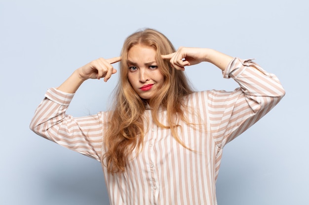 Mujer rubia con mirada seria y concentrada, haciendo lluvia de ideas y pensando en un problema desafiante