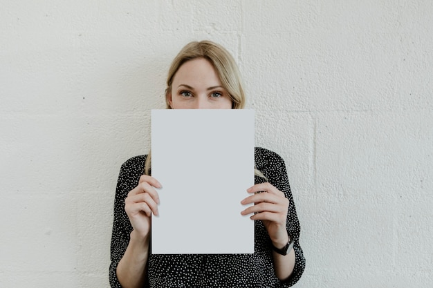 Mujer rubia mostrando un cartel blanco en blanco