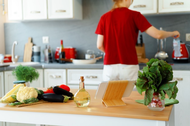 Mujer rubia de pie en la cocina y cocinar