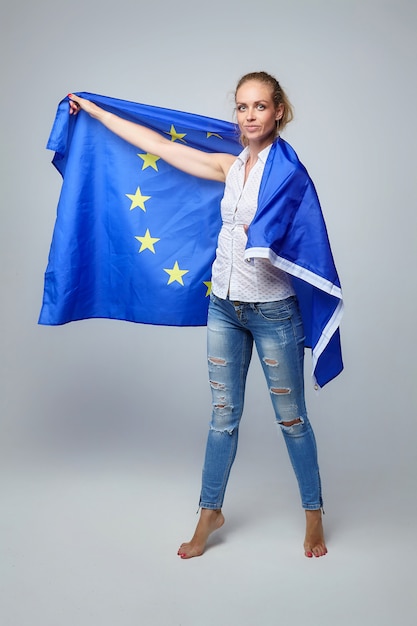 Mujer rubia. posando con la bandera de la unión europea