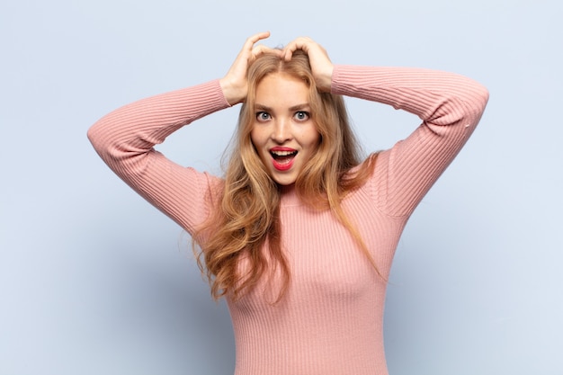 Mujer rubia que parece feliz, despreocupada, amigable y relajada disfrutando de la vida y el éxito, con una actitud positiva